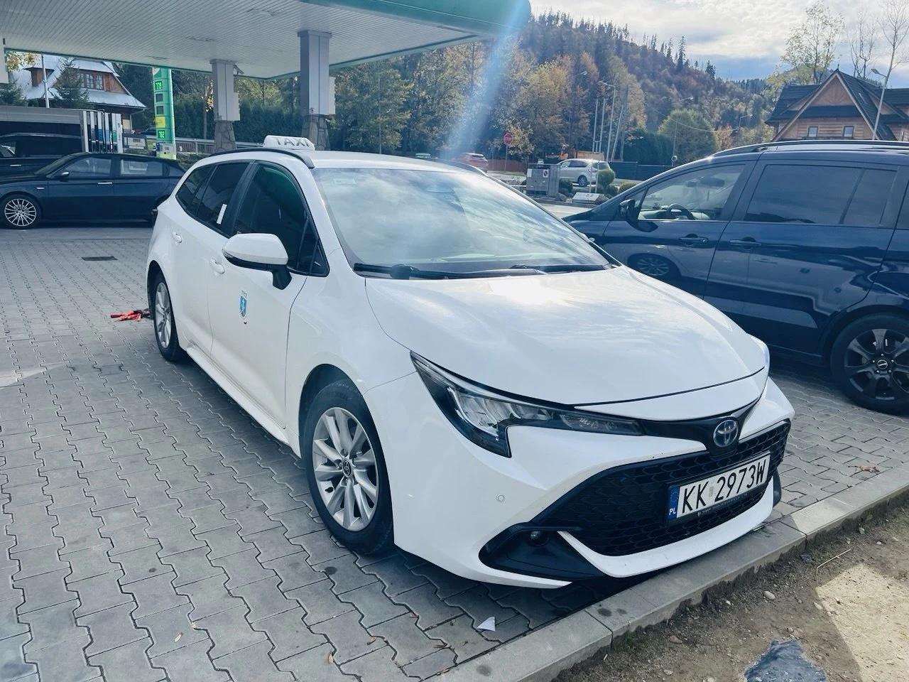 Белая Toyota Corolla и синий микроавтобус Ford